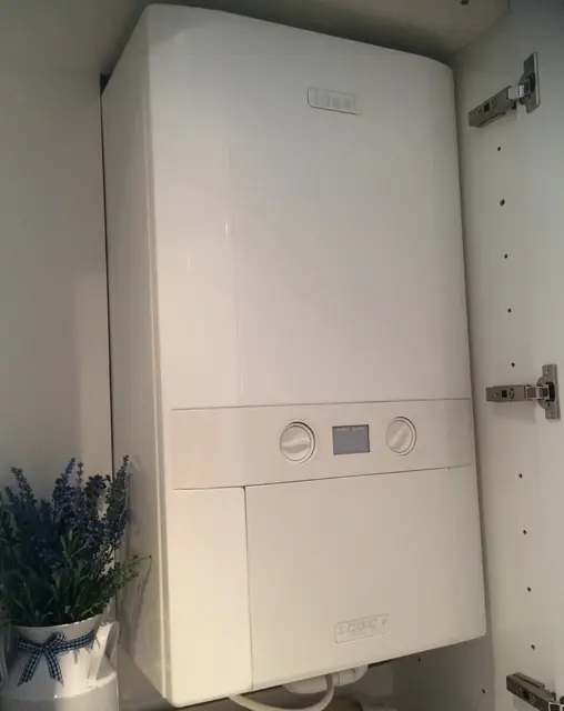Modern condensing boiler neatly installed inside a kitchen cupboard for a discreet, space-saving central heating upgrade.