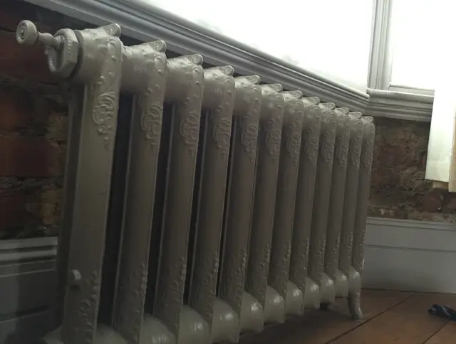 Restored ornate Victorian cast-iron radiator refinished and ready for installation in a period home.