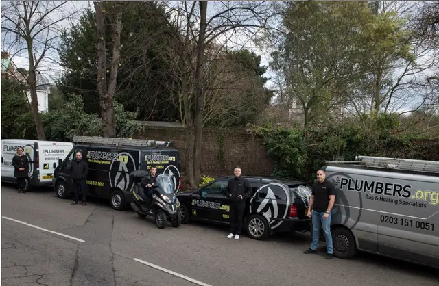 ThePlumbers.org team with the full branded fleet of vans, estate car and scooter lined up in West London.