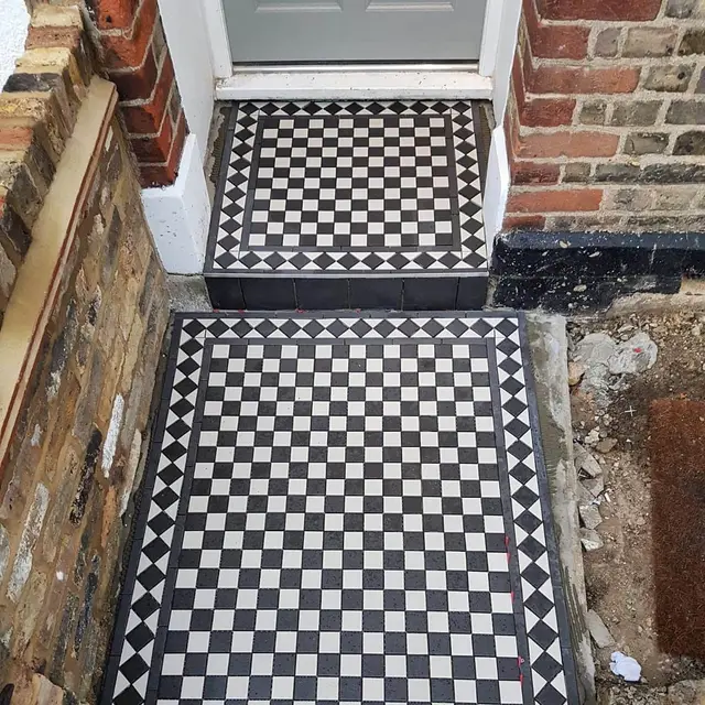 Victorian black-and-white chequer path and step tiling restoration at the entrance of a London period property.
